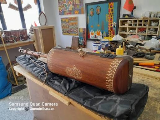 Engraved wood Guembri soundbox with carved Khamsa Hand of Fatima on the workshop table