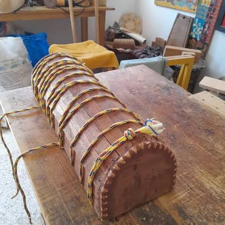 Handcrafted solid wood guembri soundbox carved by Maalem Hassan on workshop workbench
